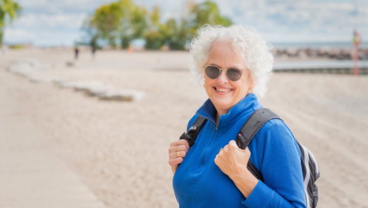 Janice with backpack on the beach